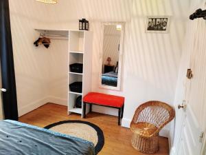 - une chambre avec un lit, un miroir et une chaise dans l'établissement LA PETITE MAISON, à Beauvais