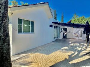 ein weißes Haus mit einem Baum davor in der Unterkunft Hermosa Casa con Alberca MC2 - 3 habitaciones max 9 huéspedes in Los Sauces