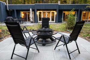a patio with a bbq grill and four chairs at earthship forest exile 
