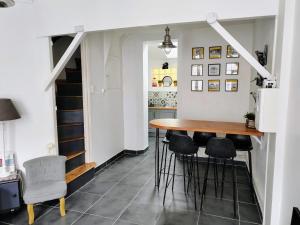 a kitchen and dining room with a table and stools at LA PETITE MAISON in Beauvais