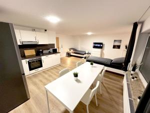 ein Wohnzimmer mit einem weißen Tisch und eine Küche in der Unterkunft Nice Apartment in Einbeck - Vogelbeck in Einbeck