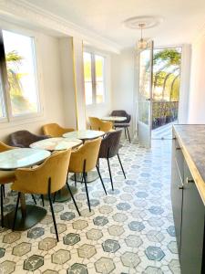 una sala da pranzo con tavoli e sedie su un pavimento piastrellato di Villa Caprice a Six-Fours-les-Plages