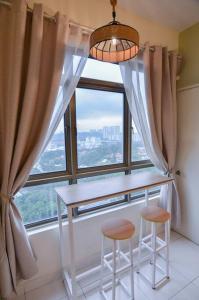 a table and two stools in front of a window at KL Art Nouveau Suite, MRT, Free Parking, Self Check In in Petaling Jaya