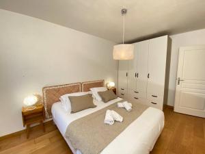 una camera da letto con un letto e due asciugamani di Maïs Cottage, terrasse ensoleillée avec vue ! ad Annecy