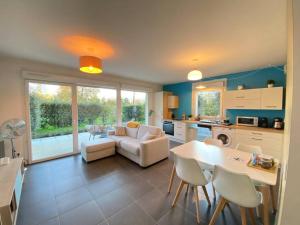 una cucina e un soggiorno con divano e tavolo di Maïs Cottage, terrasse ensoleillée avec vue ! ad Annecy