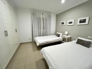 a hotel room with two beds and a window at COSTA AZUL APARTMENTS - 2B in Puerto de Mogán