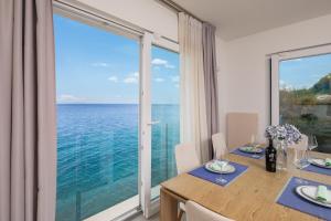 a dining room with a view of the ocean at Epetium Beach Villa in Split