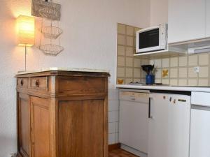 a kitchen with a wooden cabinet and a microwave at Appartement Font-Romeu-Odeillo-Via, 2 pièces, 6 personnes - FR-1-580-36 in Font-Romeu-Odeillo-Via