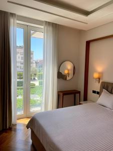 a bedroom with a bed and a large window at MBroker - Porto Montenegro Elena residence apartments in Tivat