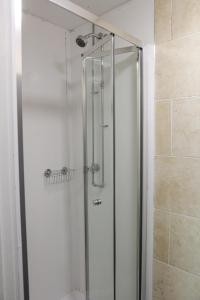 um chuveiro com uma porta de vidro na casa de banho em Onefam Waterloo 18-36 years old em Londres