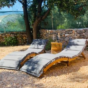 two beds sitting next to a stone wall at Beachfront Bliss - Vortex4BB in Tisno