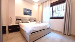 1 dormitorio con cama y ventana en Apartamentos Vacacionales Joctis, Bajo A, en Fuengirola