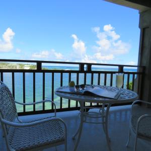 a table and chairs on a balcony with a view of the ocean at Lavista Antigua in Bats Cave