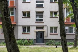 un edificio con una puerta y ventanas azules en Pušyno Apartment 1, en Klaipėda