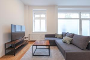 a living room with a couch and a tv at Neue 2-Zi-Apartment 15 Min Entfernung zum HBF und Brandenburger Tor in Berlin