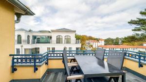 een tafel en stoelen op een balkon met een gebouw bij Kurparkresidenz Baabe Penthouse Windjammer in Baabe +20 foto's