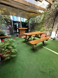 a wooden picnic table in a patio with plants at The Western in St Ives