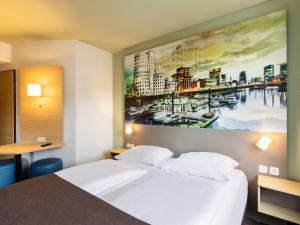 デュッセルドルフにあるB&B Hotel Düsseldorf City-Südのベッド付きの客室で、壁には絵画が飾られています。