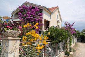 una casa con flores de colores en una valla en Apartments Biskup, en Privlaka