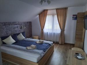 a bedroom with a bed with shoes on it at Casa Truța in Topliţa