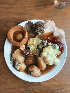 a plate of food with mushrooms and onion rings on a table at The Western in St Ives