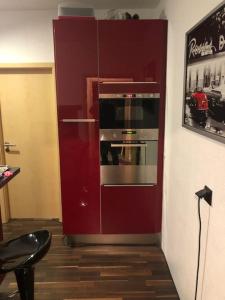 a red cabinet with an oven in a room at Casa DelSillie ... Magnet Pin Welcome in Bochum
