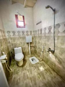 a bathroom with a toilet and a shower at Jabal Shams Al-Salam house in Sa‘ab Banī Khamīs