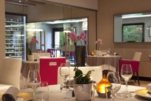 L'Aubinière Hôtel Restaurant & Spa في Saint-Ouen-les-Vignes: غرفة طعام مع طاولات وكراسي مع كؤوس للنبيذ