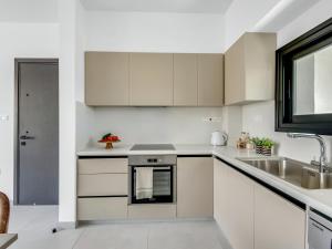 a kitchen with white cabinets and a sink at Sanders Cruise-Spacious 2-bdr apt w2 balconies in Limassol