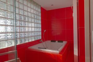 La salle de bains rouge est pourvue d'une baignoire avec un mur rouge. dans l'établissement ''PARIS'' - Luxe Apartment with Amazing Seaview, à Ostende