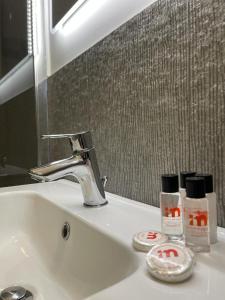 un lavandino con rubinetto e specchio di IMHOME - Porta Vittoria a Milano