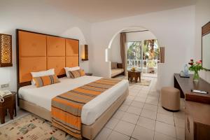 a bedroom with a large bed with a desk and a desk at Monarque Club Rivage - VV in Monastir