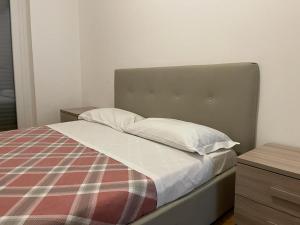 a bed with a plaid blanket and two pillows at IMHOME - Porta Vittoria in Milan