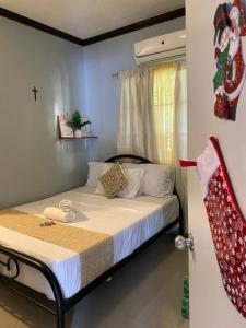 sypialnia z łóżkiem z krzyżem na ścianie w obiekcie Angel's Place Transient House w mieście Tagbilaran