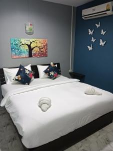 1 dormitorio con 1 cama blanca con mariposas en la pared en Krabi Nemo House, en Ao Nang Beach