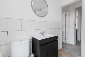 a bathroom with a sink and a toilet and a mirror at 1bed apartment with parking close to City Centre in Thorpe Saint Andrew
