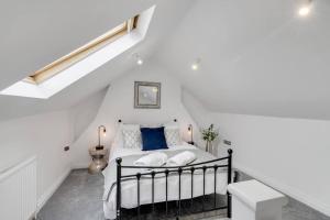 a white bedroom with a bed with blue pillows at 1bed apartment with parking close to City Centre in Thorpe Saint Andrew