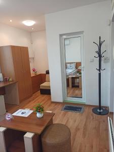a living room with a table and a mirror at Gabrovo Relax Apartment in Gabrovo