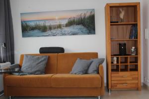 a couch in a living room with a picture of a beach at Urlaub im Herzen von Laboe in Laboe