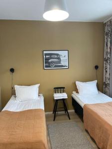 a bedroom with two beds and a picture of a car at Light modern Pallo apartment by the lake Saimaa in Lappeenranta