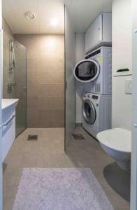 a bathroom with a washing machine and a washer at Light modern Pallo apartment by the lake Saimaa in Lappeenranta