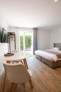 - une chambre avec un lit, une table et un lit dans l'établissement LOGIS LES CEPAGES / RESTAURANT LE RAISIN, à Pont-de-Vaux