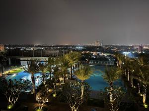 a view of a pool with palm trees at night at Moon's Home in Ho Chi Minh City