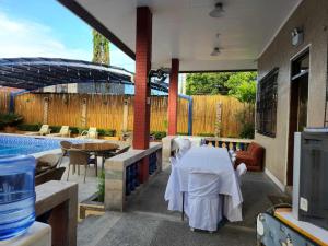 eine Terrasse mit einem Tisch, Stühlen und einem Pool in der Unterkunft TRD Private Hotspring Resort in Pansol