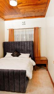 ein Schlafzimmer mit einem großen Bett und einem Fenster in der Unterkunft Naivasha TownHouse in Naivasha