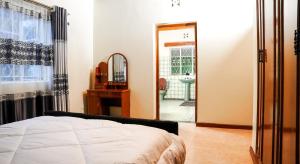 a bedroom with a bed and a mirror and a bathroom at Naivasha TownHouse in Naivasha