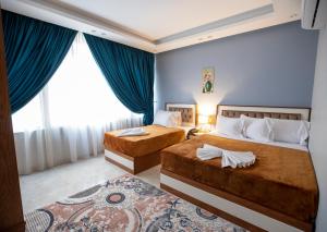 El Shams Plaza Hotel في القاهرة: سريرين في غرفة بجدران زرقاء