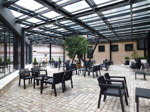 a patio with black chairs and tables in a building at MIK Hotel Korce in Korçë