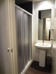 a bathroom with a sink and a shower with a mirror at Hotel Irixo in Ourense
