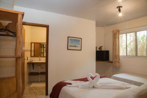 um quarto com uma cama com toalhas em Morada do Gabriel em Guarda do Embaú